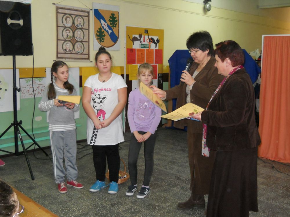 Na zdjęciu widać 3 dziewczynki odbierające nagrody od 2 pań za udział w konkursie.